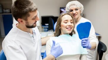 young male dentist howing sample dentures his patient dentist office lifestyle scene doctor practice patient health care 105751 1501