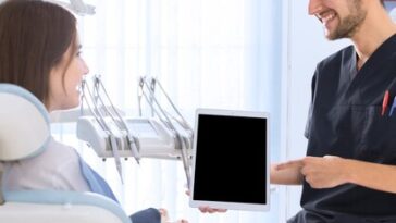 happy dentist pointing digital tablet screen female patient clinic 23 2147879183 1