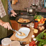 Food and Cooking for Health: A Guide to Nourishment 20 cropped man apron putting fried chicken from frying pan plate 1 1