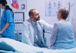 elderly woman doctor appointment modern private clinic while she sitts hospital bed physician is listening her heart beat health care medicine treatment specialist consultation 1