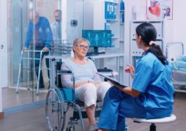 nurse talking with senior woman with walking disabilities sitting wheelchair into private modern recovery clinic hospital handicapped old retired patient medical consultation advice 1