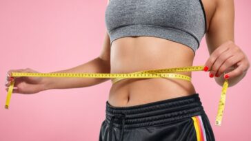 close up slim woman measuring her waist s size with tape measure isolated pink background 159057 1214