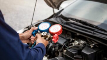 close up hand auto mechanic are using manifold gauge filling car air conditioners 1