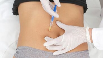 Woman receiving Aqualyx injection to stomach