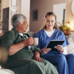 nurse tablet consultation with senior woman home with results news coffee medical report sofa people caregiver digital touchscreen with laugh healthcare support with app 590464 485308
